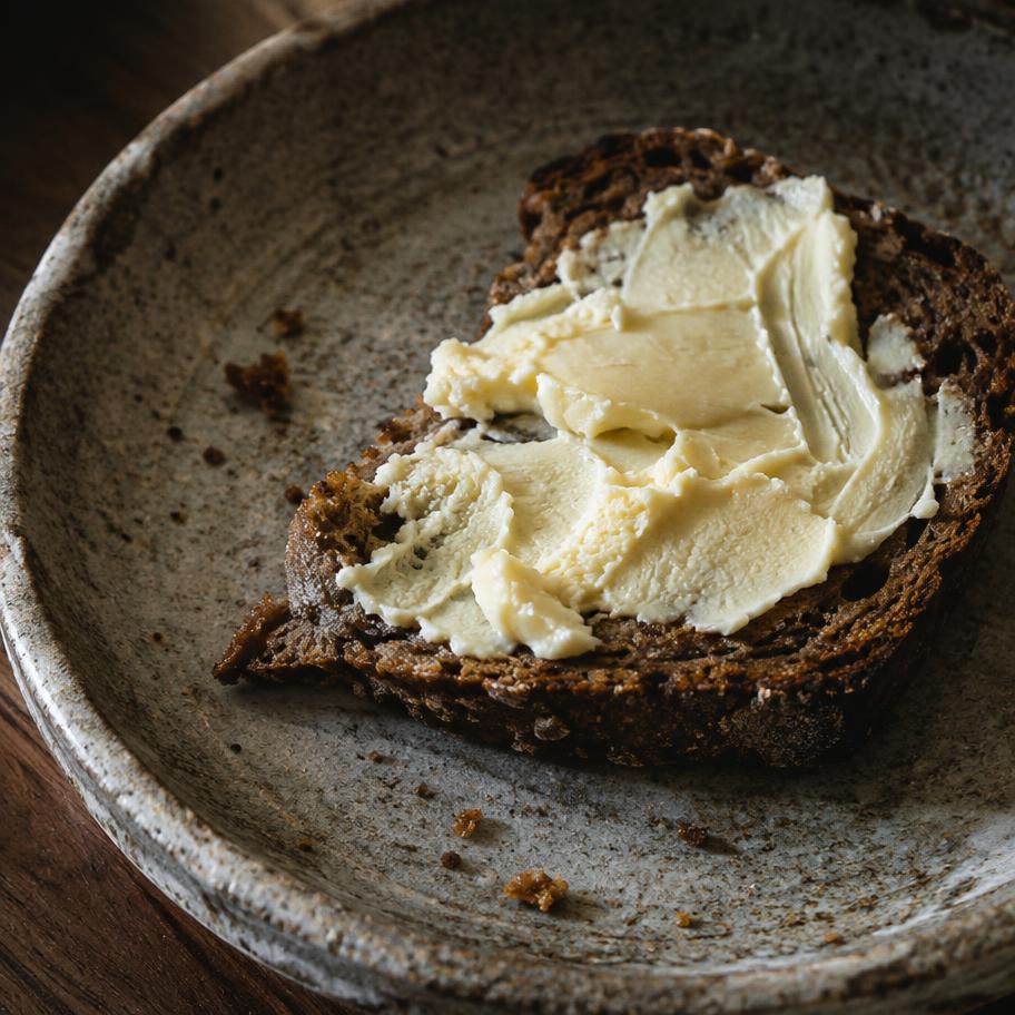 Scheibe Roggenbrot mit Butter auf einem Keramikteller